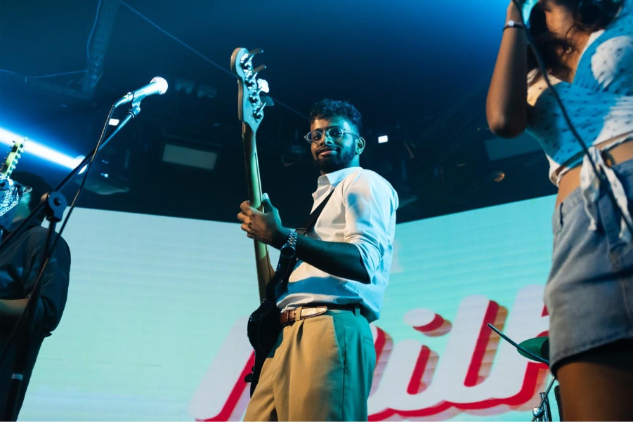 A group of people playing instruments on stage Description automatically generated